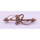 An Edwardian 9 ct gold and seed pearl harp bar brooch. 5 cm long. 2.9 grammes total weight.