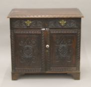 A Victorian carved oak side cupboard. 102 cm wide.