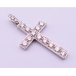 An unmarked white gold or platinum diamond set cross pendant. 4 cm high including suspension loop.