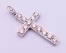 An unmarked white gold or platinum diamond set cross pendant. 4 cm high including suspension loop.