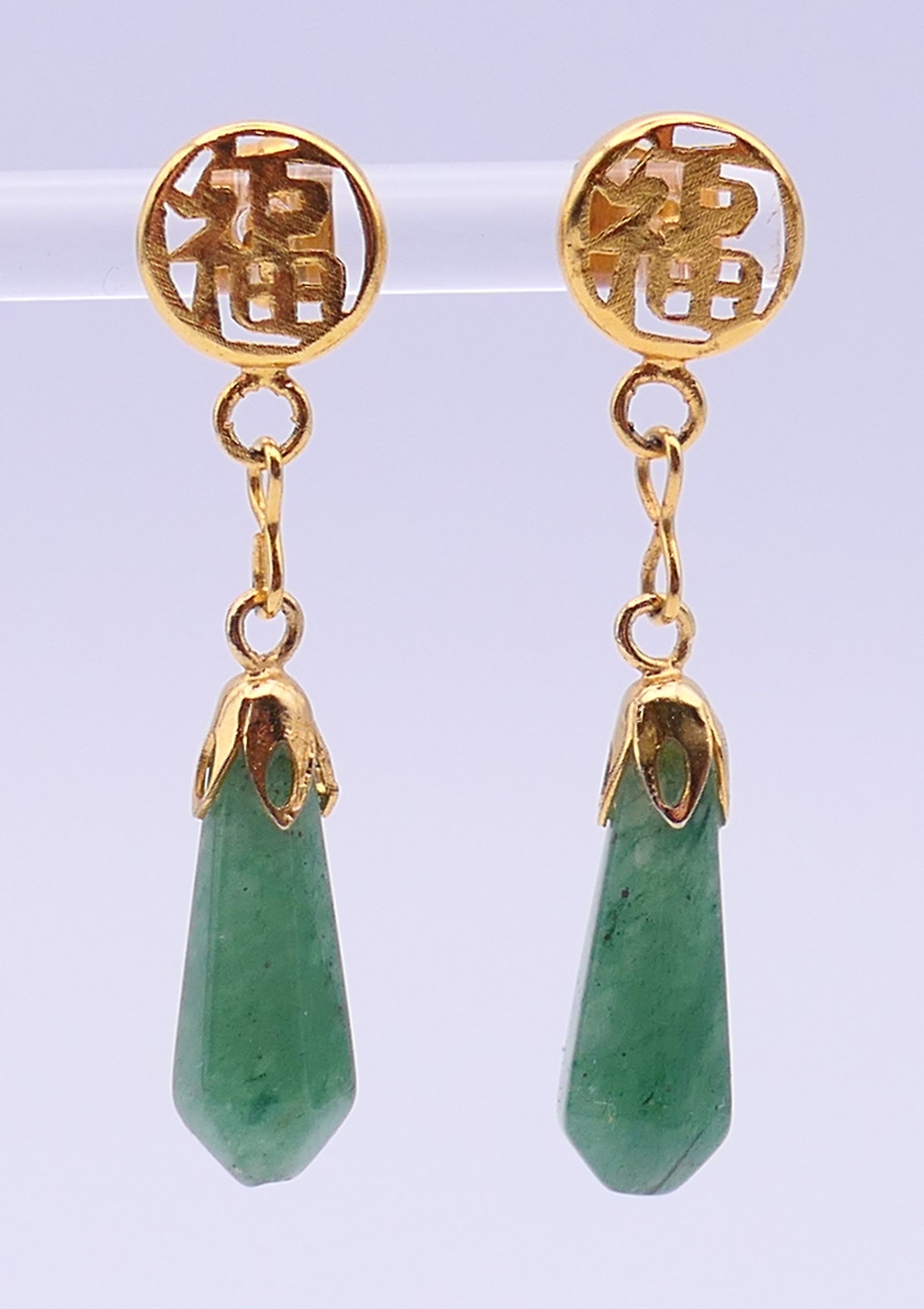 A pair of Chinese unmarked yellow metal mounted jade earrings. 4 cm high.