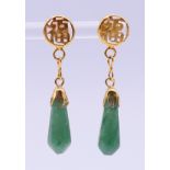 A pair of Chinese unmarked yellow metal mounted jade earrings. 4 cm high.