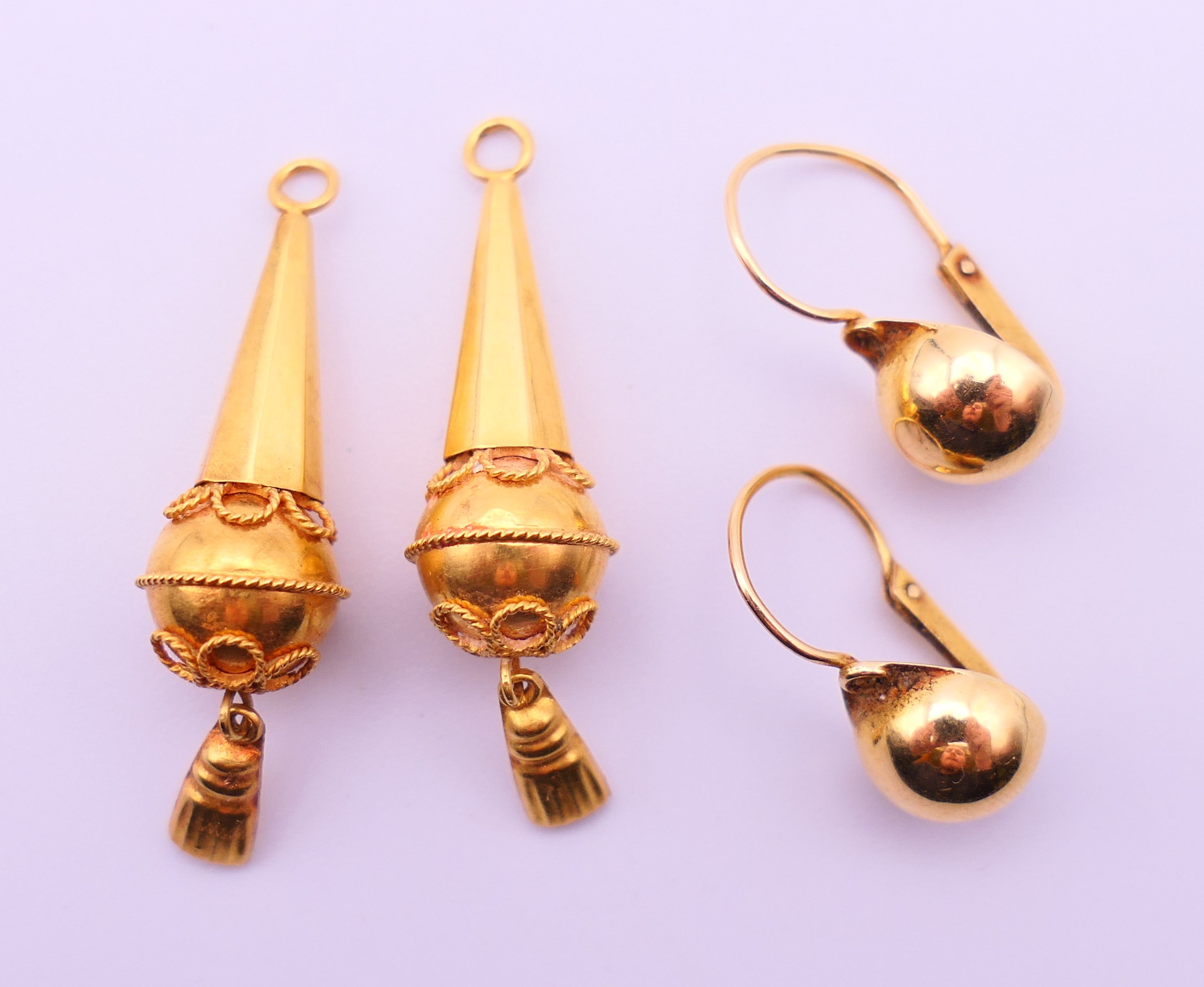 Two pairs of unmarked gold earrings. 3.5 cm high and 1 cm diameter respectively. 4.9 grammes.