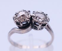 An 18 ct white gold two-stone diamond crossover ring. Ring size L/M.
