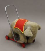 A vintage plush-covered push along elephant toy. 46 cm long.