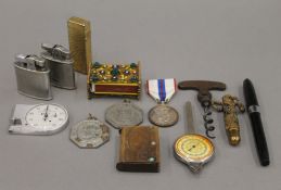 A quantity of miscellaneous items, including lighters, medallions, a pen, etc. The pen 13 cm long.