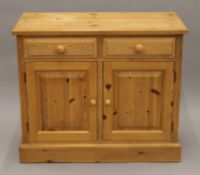 A modern pine side cupboard. 99.5 cm wide.