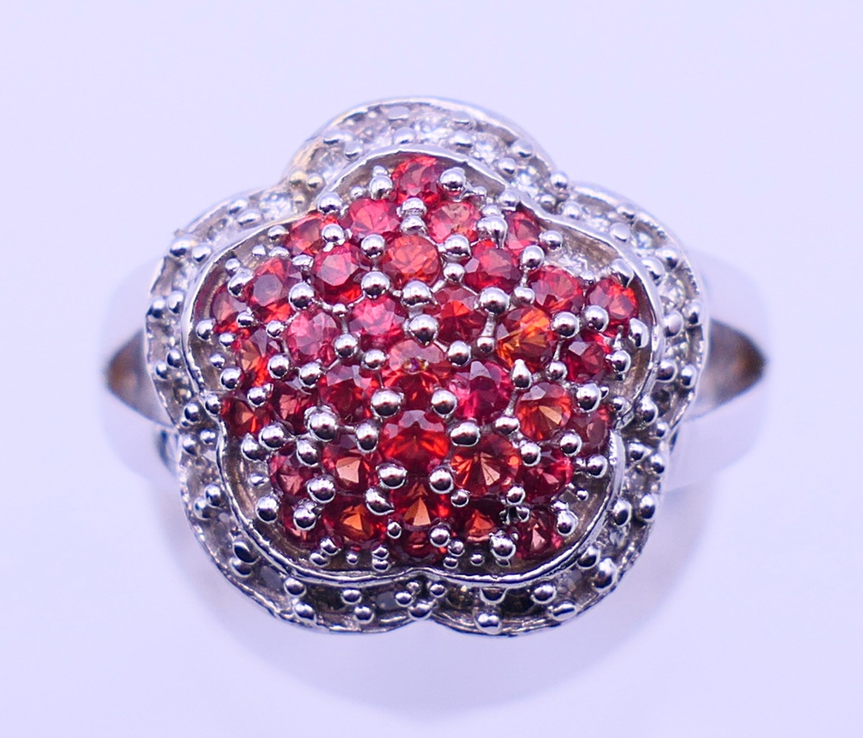A 14 K white gold cluster ring. Ring size M. 8.1 grammes total weight.