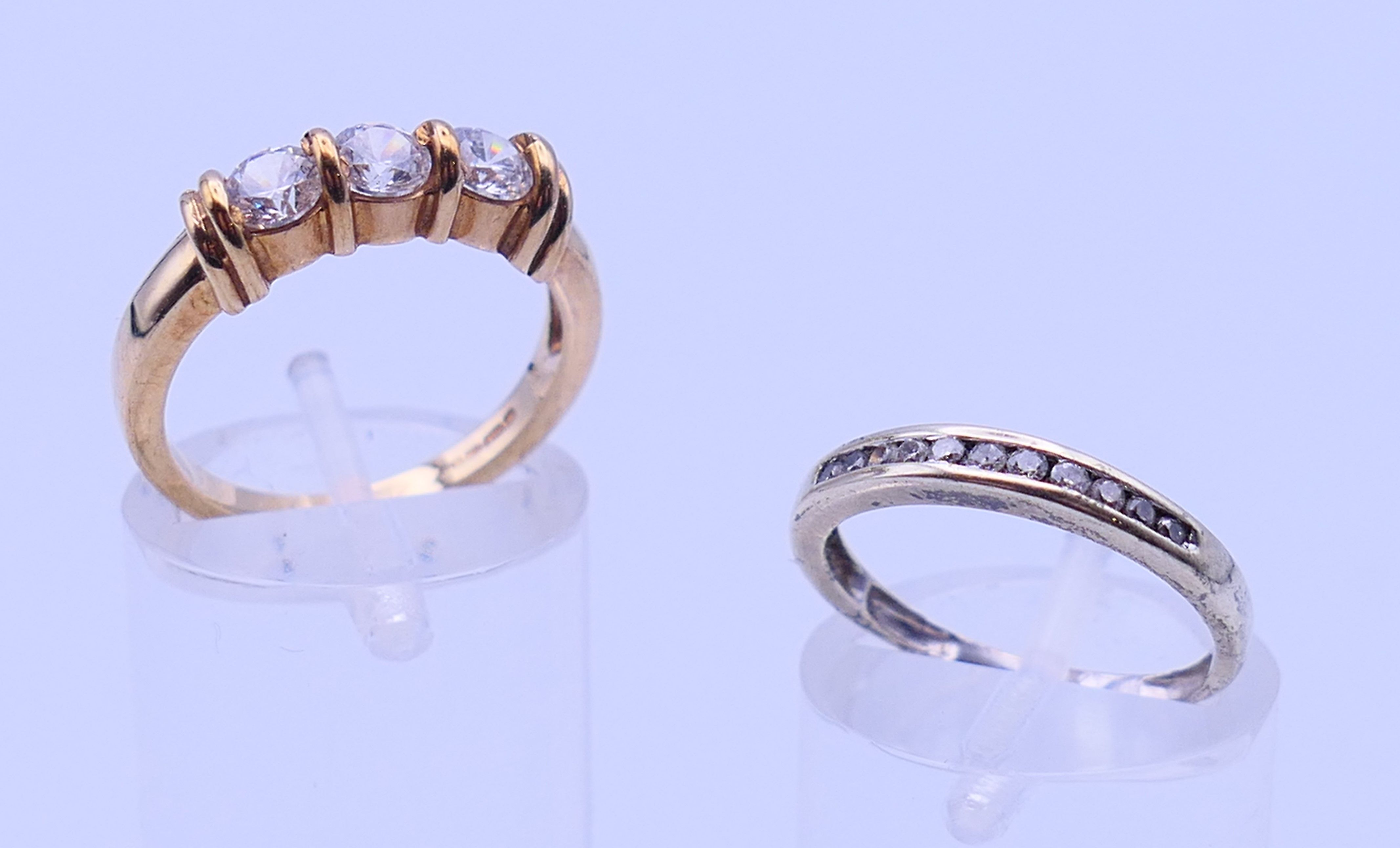 A 9 ct gold three-stone ring and an unmarked half hoop eternity ring. The former, Ring size M and 3.