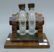 A pair of unmarked silver-mounted crackle glaze decanters on a rosewood stand,