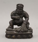 A carved stone model of the Buddhist deity Jambhala (Dzambhala). 15 cm high.