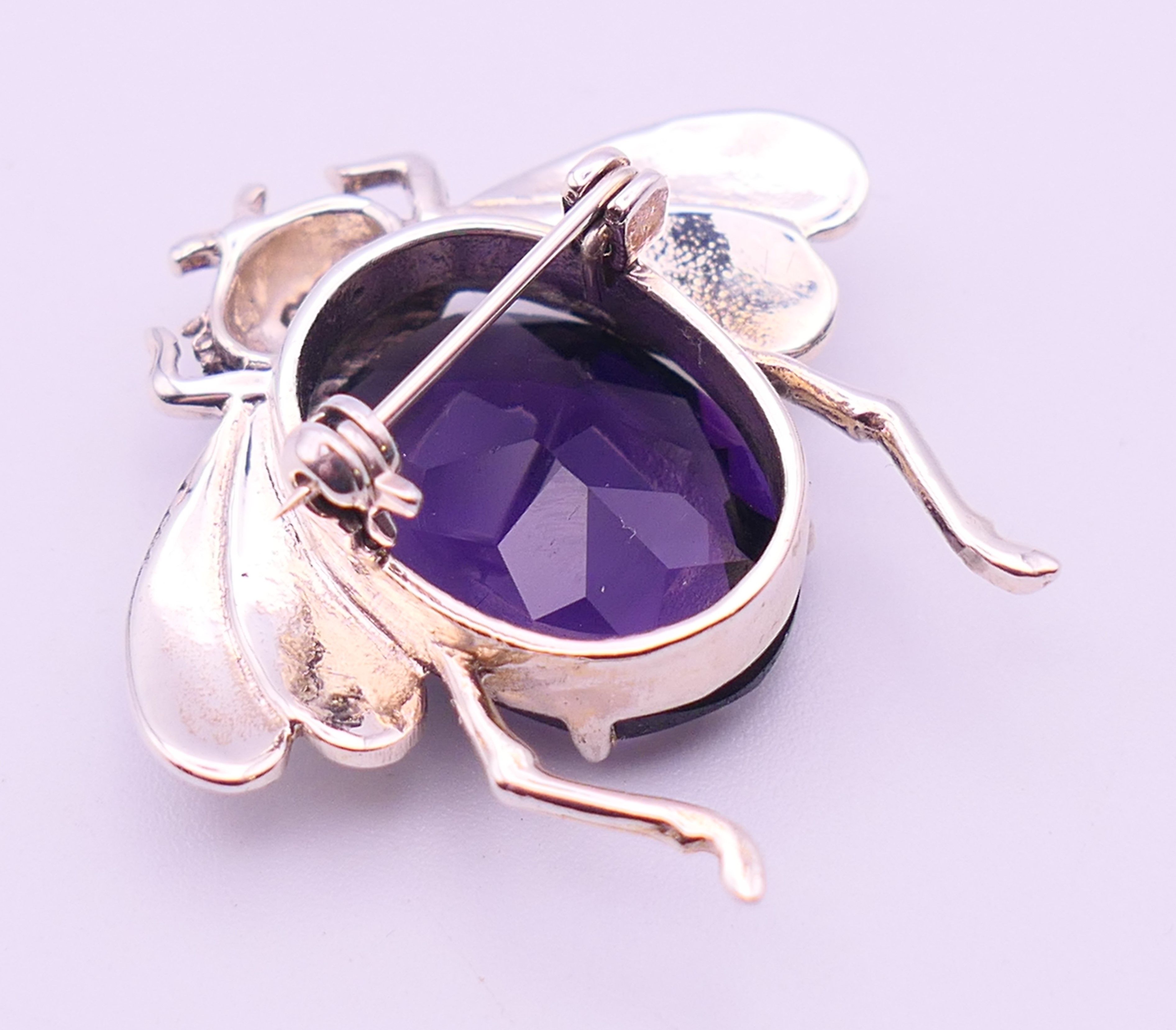 A silver bee form brooch with purple stone body and pink stone inset eyes. 3.5 cm high. - Image 3 of 4