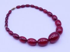 A string of graduated cherry amber colour beads and one loose bead. Necklace 40 cm long.