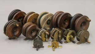 A collection of vintage brass and wooden fishing reels. The largest 10.5 cm diameter.
