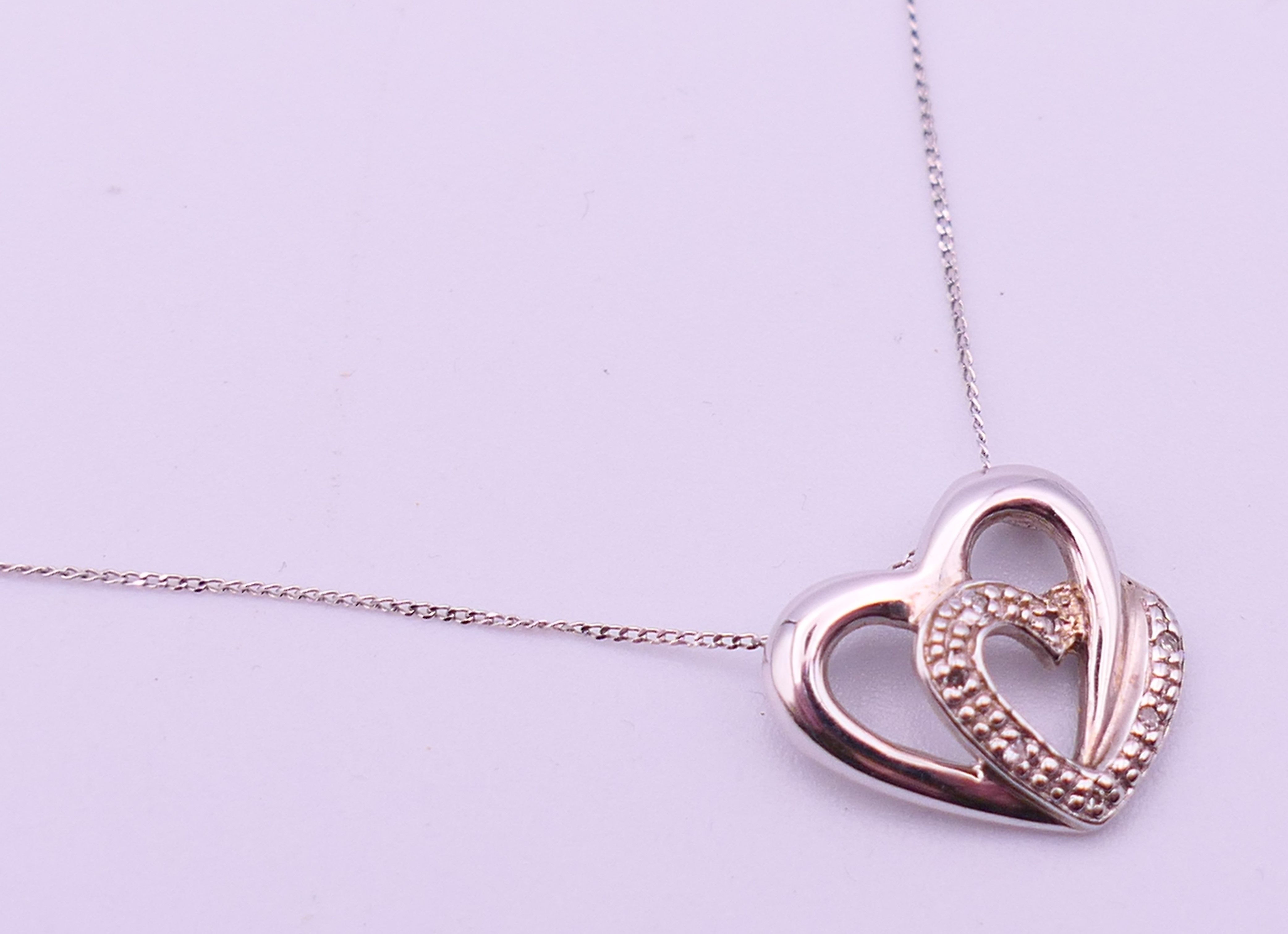 A 9 ct white gold and diamond double heat pendant on a 9 ct white gold chain. Pendant 1. - Image 4 of 8