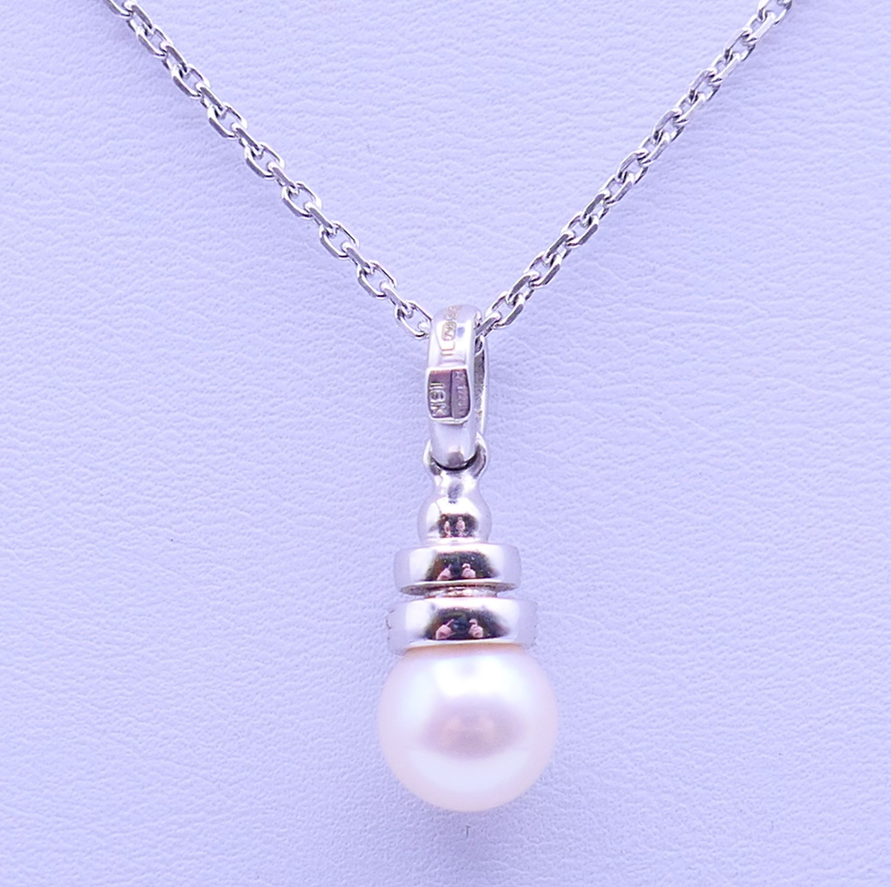 An 18 ct white gold, diamond and pearl drop pendant on a chain. Pendant 2.