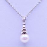 An 18 ct white gold, diamond and pearl drop pendant on a chain. Pendant 2.
