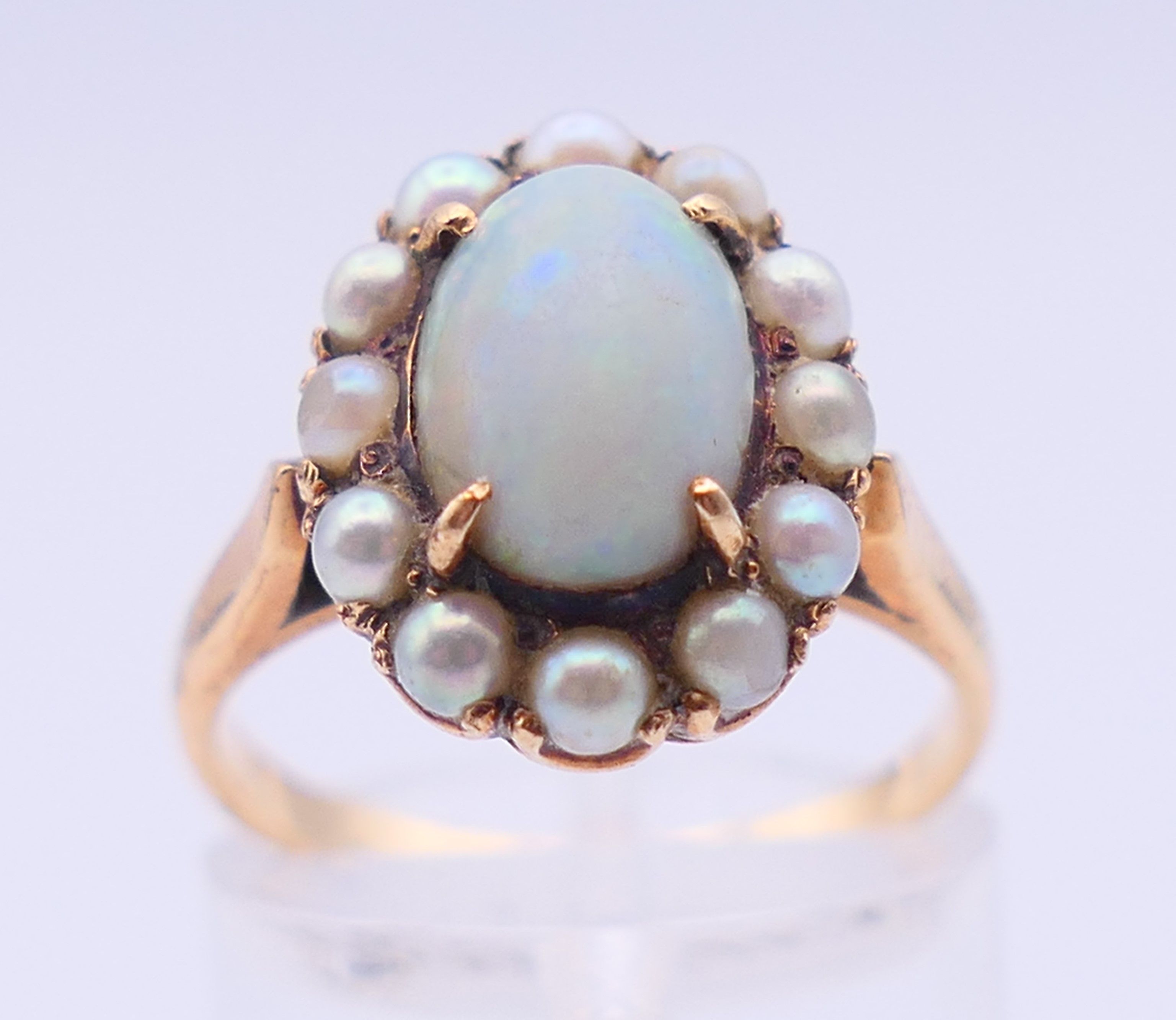 An unmarked gold, opal and seed pearl ring. Ring size M/N. 4 grammes total weight. - Image 2 of 5