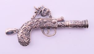 A silver gun pendant. 6.5 cm long.