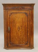 A George III inlaid oak and mahogany corner cupboard. 77.5 cm wide x 104 cm high.