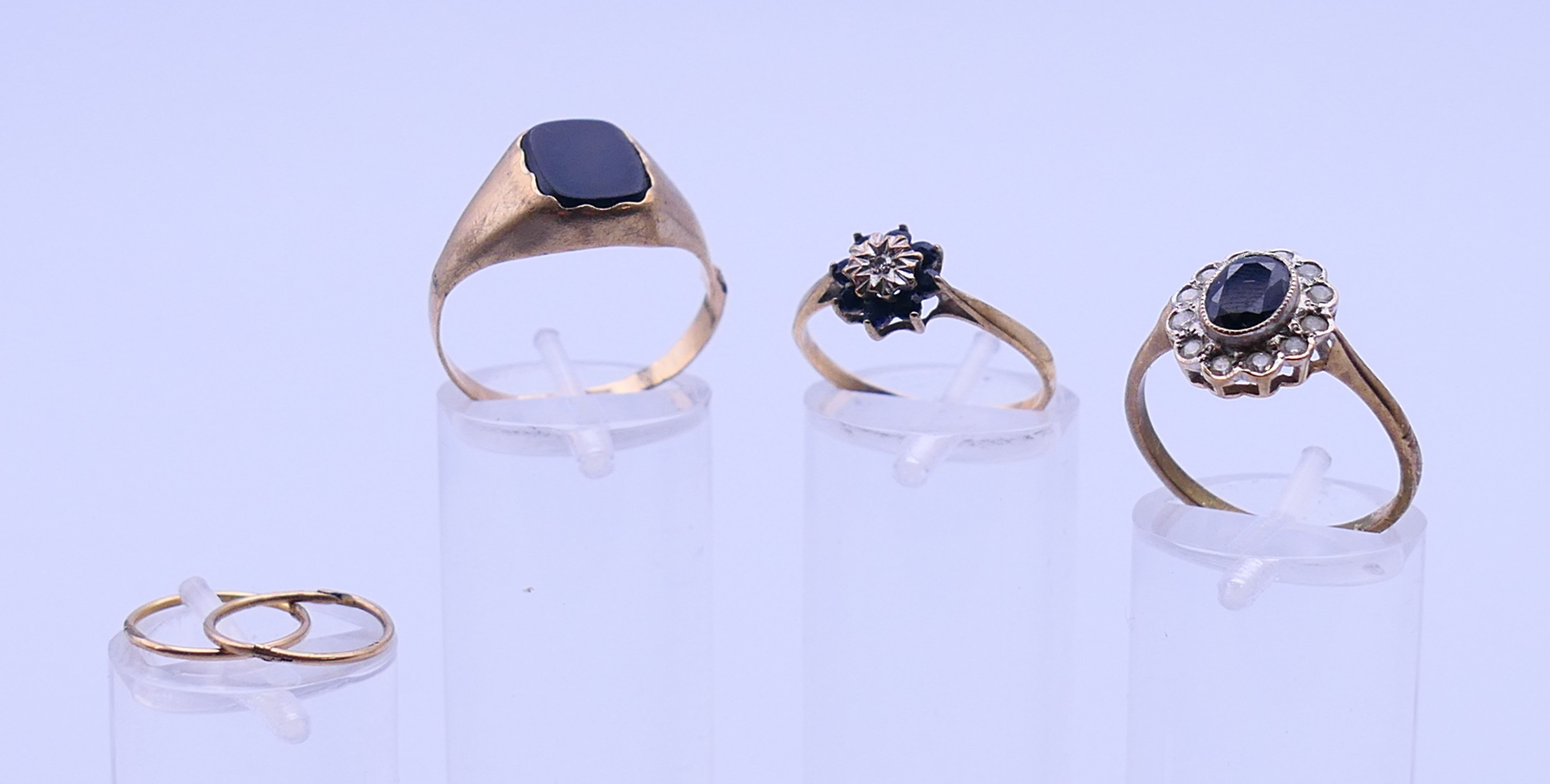 Two 9 ct gold rings, an unmarked gold signet ring and a pair of 9ct gold hoop earrings.