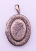 A Victorian engraved silver (tested) double photograph locket containing photographs. 6 cm high.