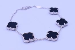 A silver and black onyx clover bracelet. 18 cm long.
