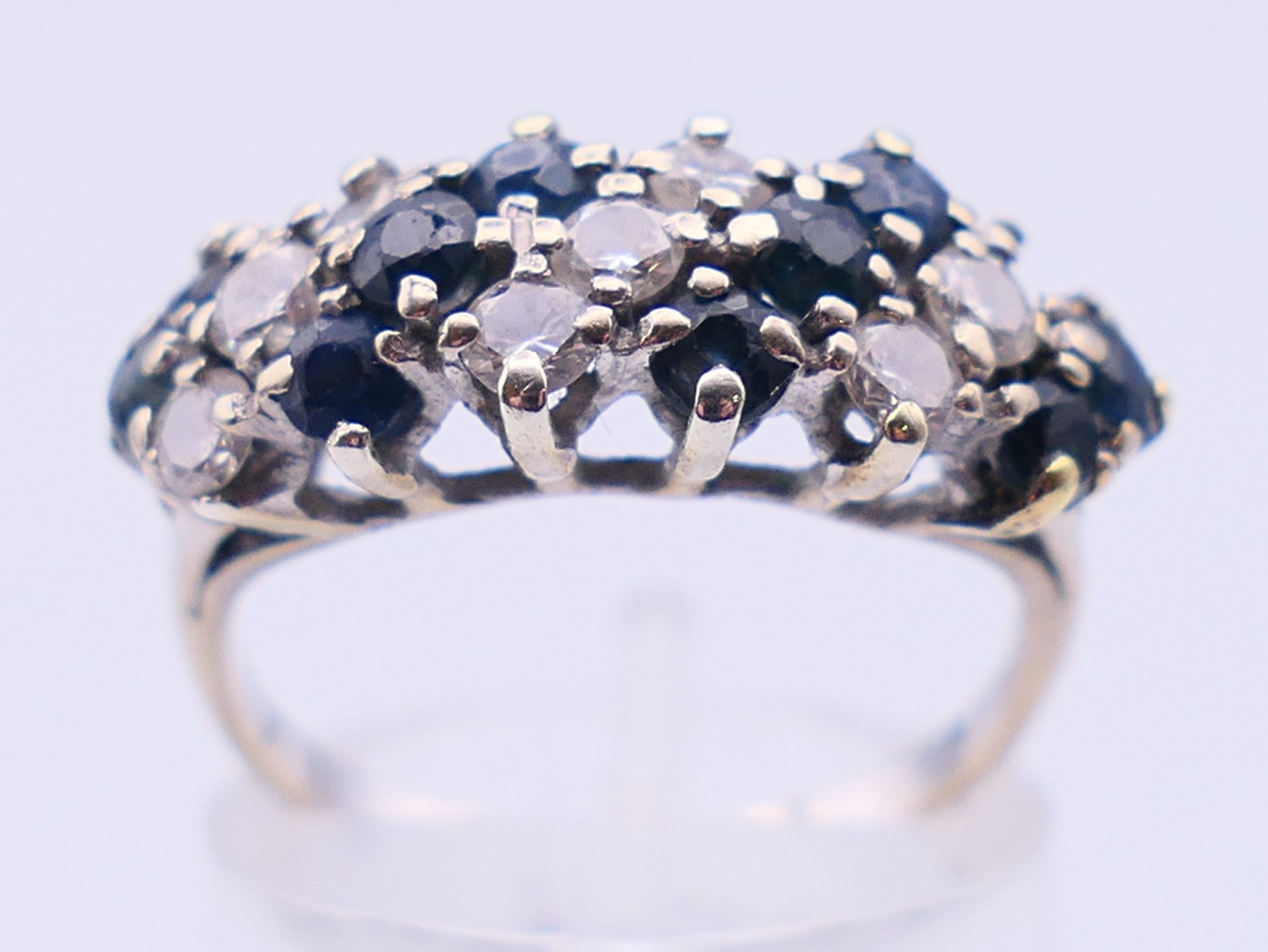 An unmarked white gold or platinum, diamond and sapphire ring. Ring size N. 4 grammes total weight. - Image 2 of 5