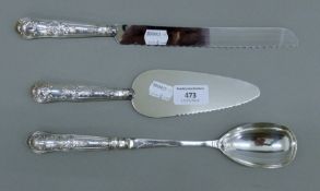 A silver-handled bread knife, a silver-handled pie server and a silver-handled serving spoon.