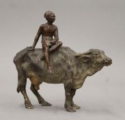 An Austrian cold-painted bronze model of a boy riding an oxen. 15 cm long.