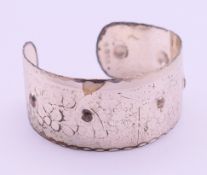 A silver bangle. 5 cm diameter.