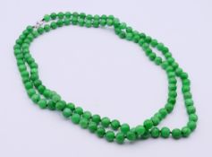 A jade bead necklace with an 18 ct white gold clasp. 126 cm long.