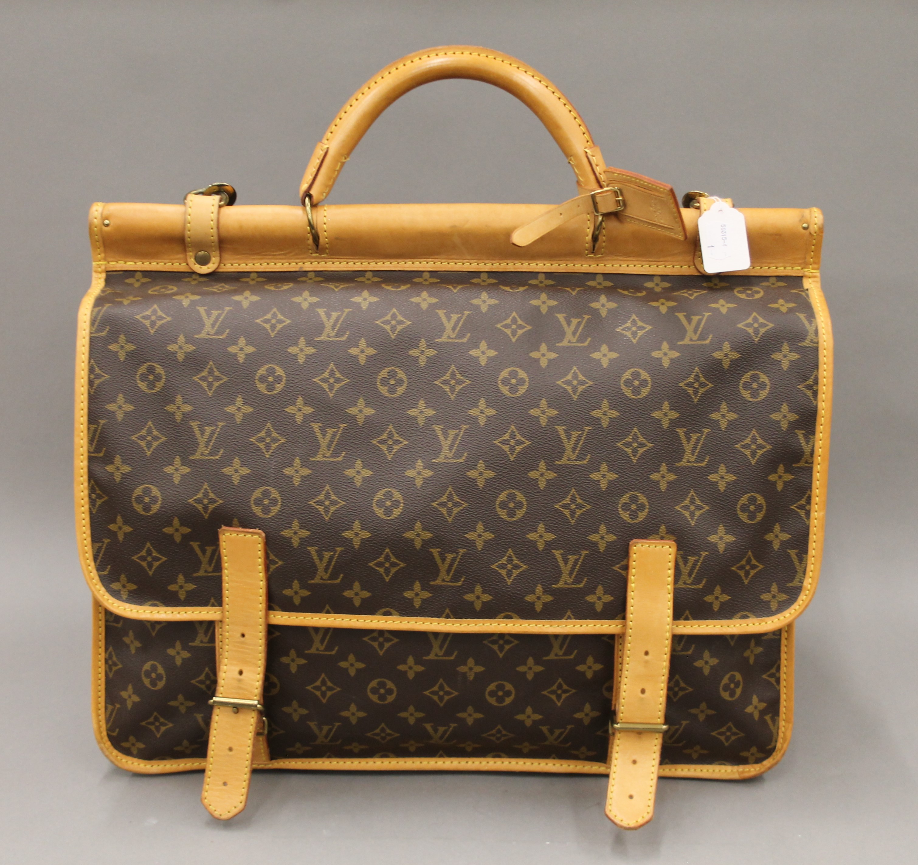 A vintage 1980's Louis Vuitton three-pocket travel bag with leather trim and shoulder strap.