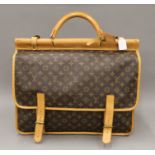 A vintage 1980's Louis Vuitton three-pocket travel bag with leather trim and shoulder strap.