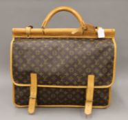 A vintage 1980's Louis Vuitton three-pocket travel bag with leather trim and shoulder strap.