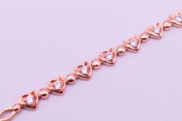 A silver gilt cubic zirconia heart bracelet. 18.5 cm long.