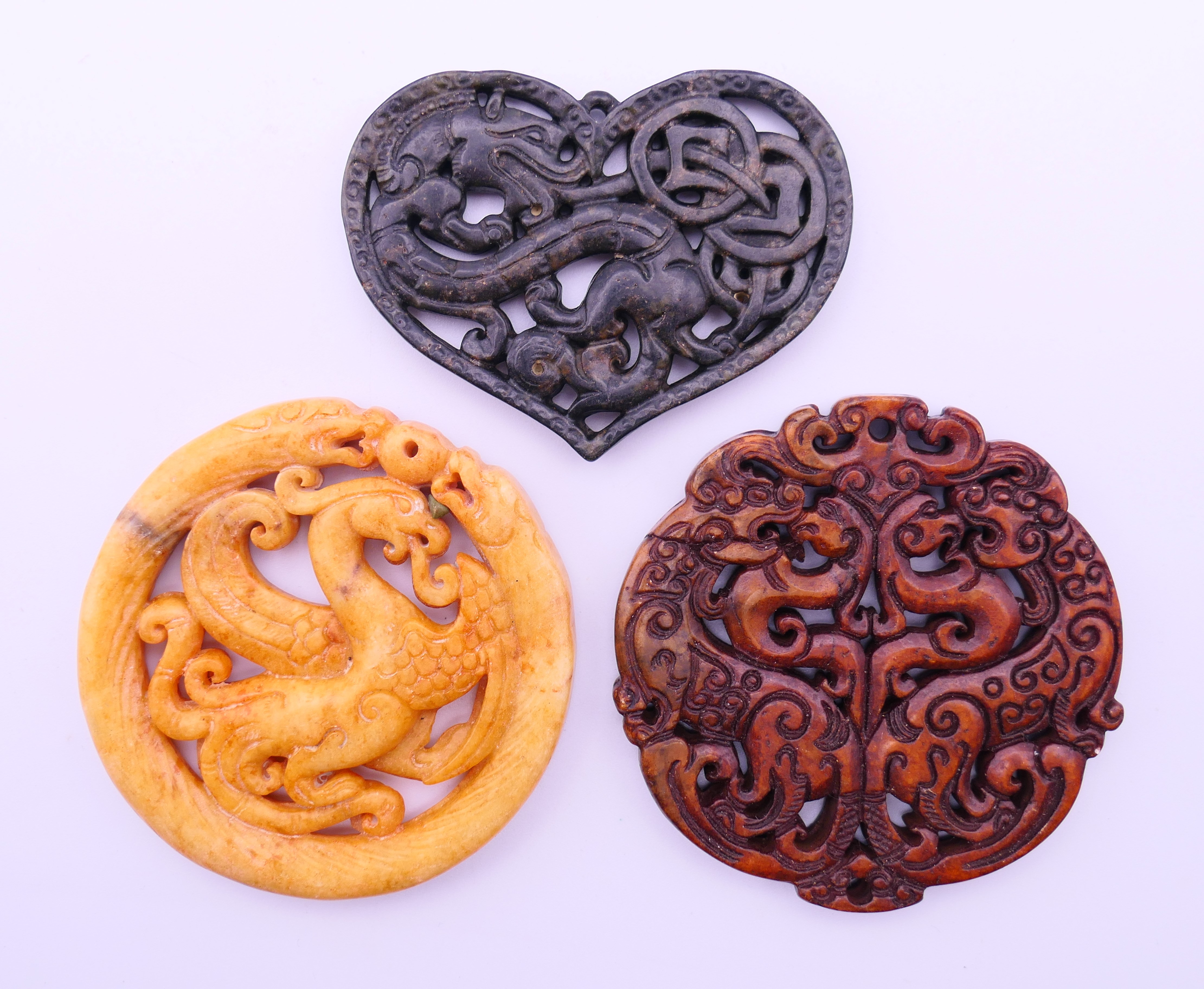 Three Chinese stone discs. The largest 7 cm diameter.