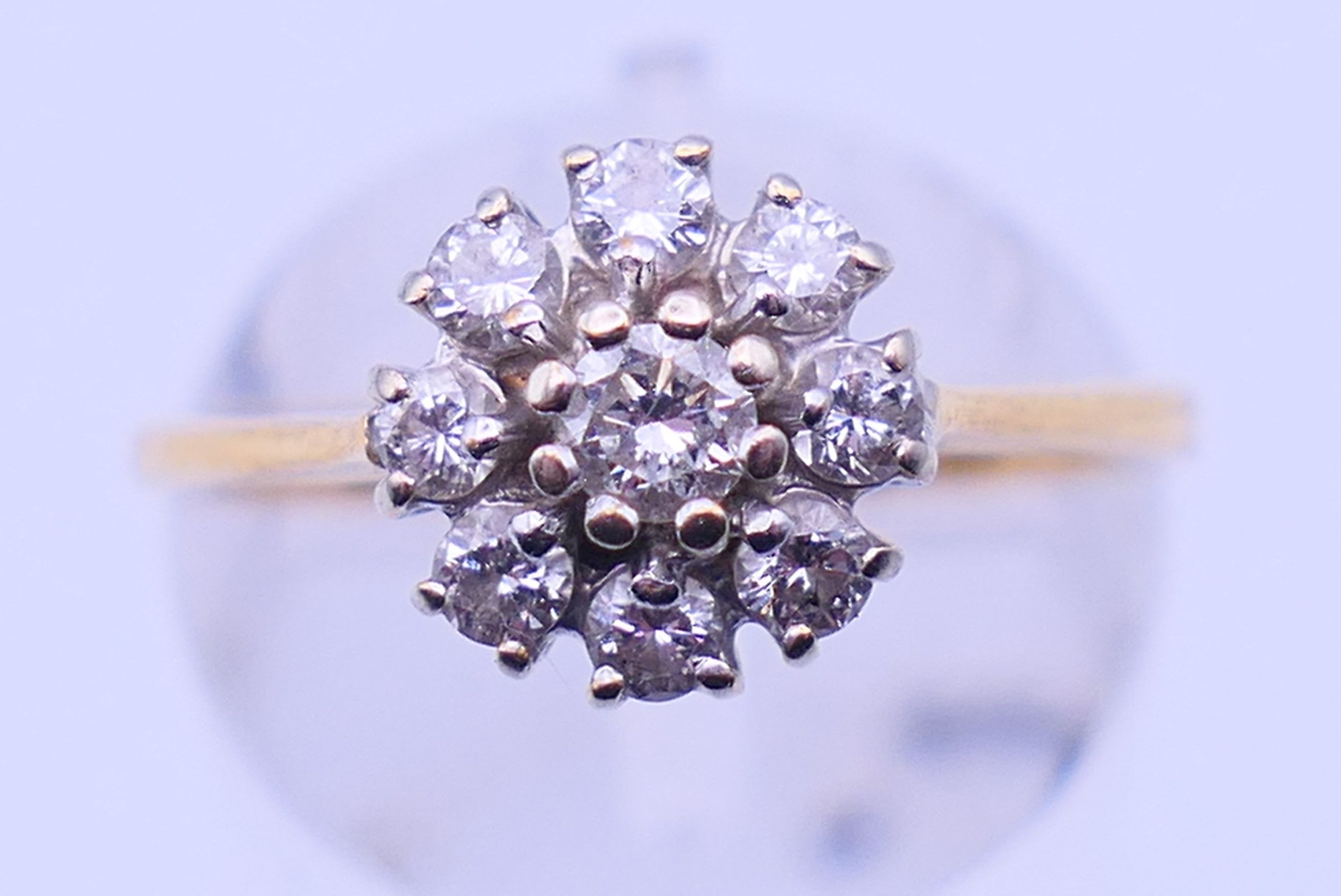 A gold and diamond daisy ring. Ring size M. 3.3 grammes total weight.