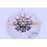 A gold and diamond daisy ring. Ring size M. 3.3 grammes total weight.