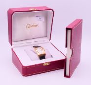 A boxed 18 ct gold Cartier Tank Americaine gentlemen's wristwatch. 3 cm wide including crown.