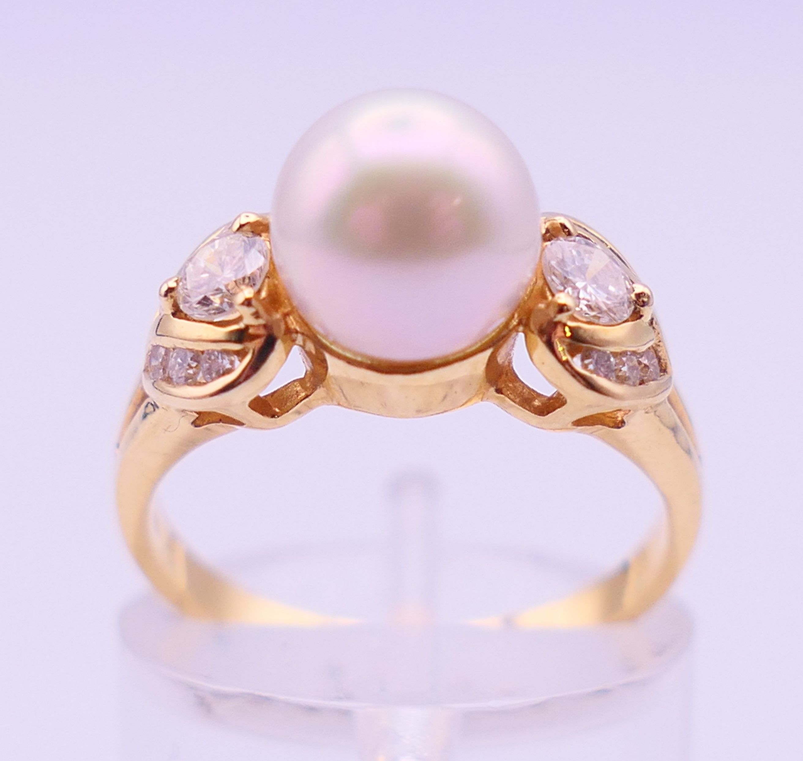 An 18 ct gold, diamond and pearl ring. Ring size L/M. 3.9 grammes total weight.