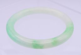 A Chinese jade light green to apple green bangle. 0.75 cm high, 5.5 cm internal diameter.