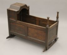 An 18th/19th century oak crib. 94 cm long.