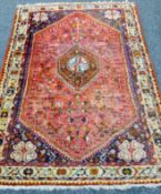 A Persian red ground wool rug. 175 x 110 cm.