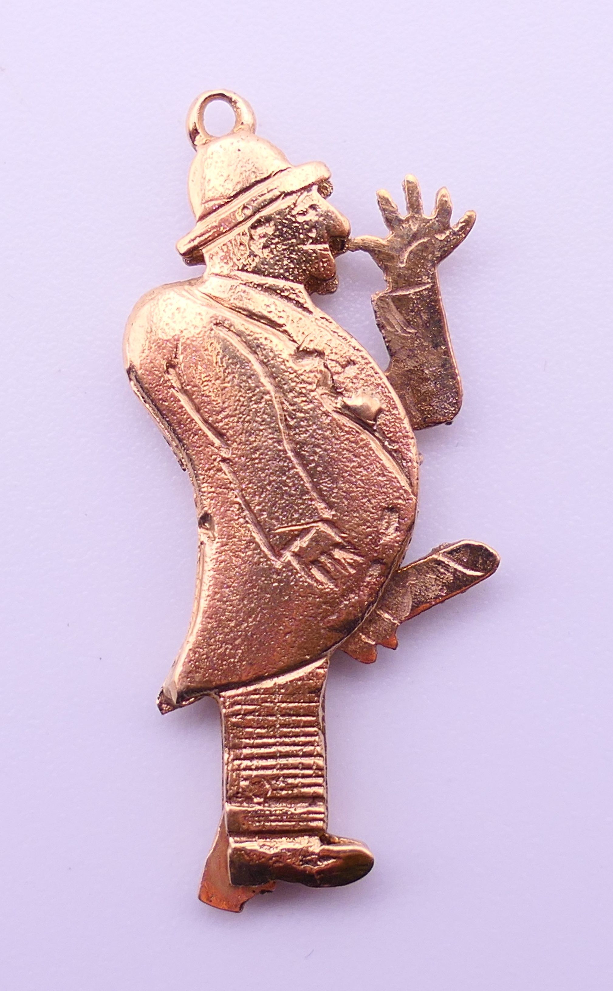 A 9ct gold charm/pendant formed as a flashing man. 3 cm high. 2.4 grammes total weight. - Image 2 of 3