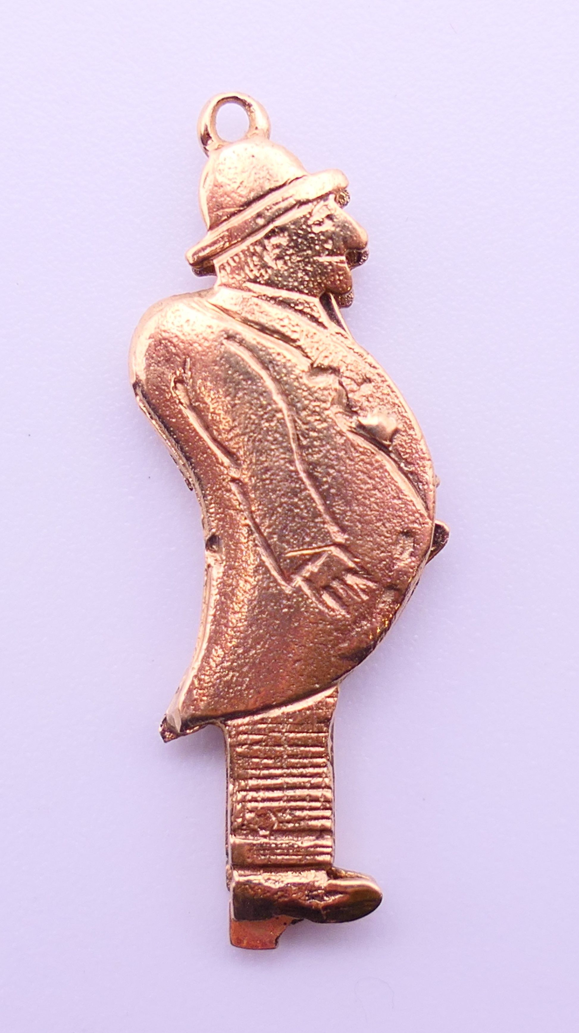 A 9ct gold charm/pendant formed as a flashing man. 3 cm high. 2.4 grammes total weight.