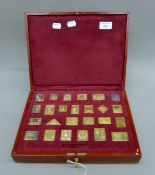 A cased set of gold-plated sterling silver replicas of the Empire stamp collection.