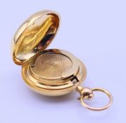 A 9 ct gold sovereign holder. 3 cm diameter (excluding suspension loop). 11.2 grammes total weight.