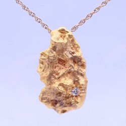 A diamond set 22 ct gold nugget pendant on an unmarked chain. The pendant 4 cm high. 46.