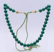 A single strand malachite bead adjustable necklace. Maximum length 100 cm, minimum 52 cm long.